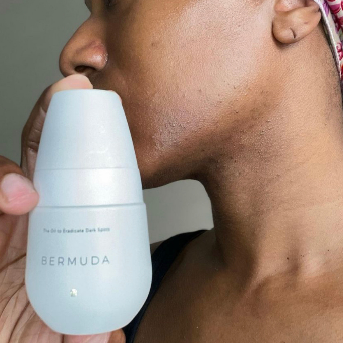 A hand holding the Bermuda Dark Spot roller against the jawline